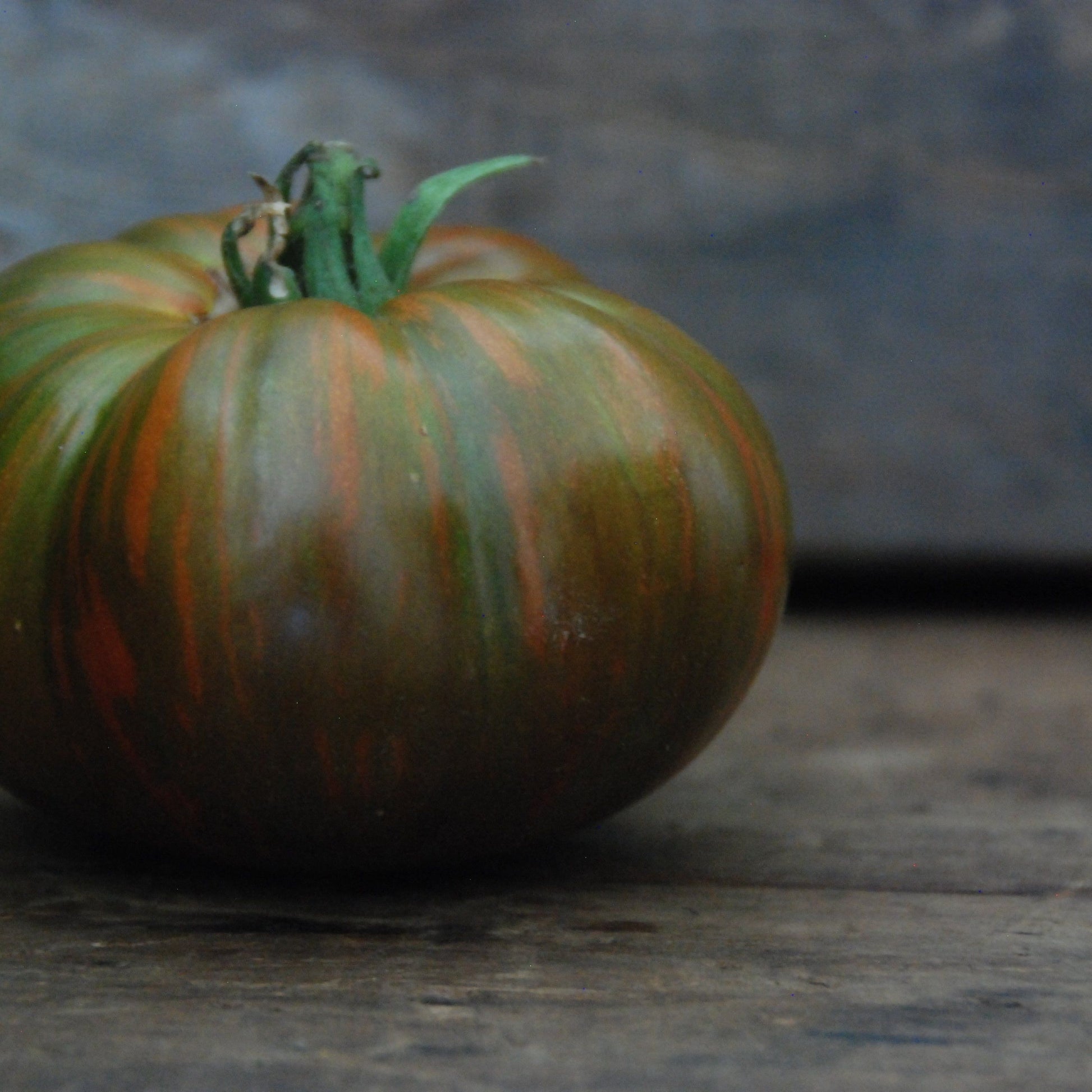 brown and green striped tomato on wooden surface