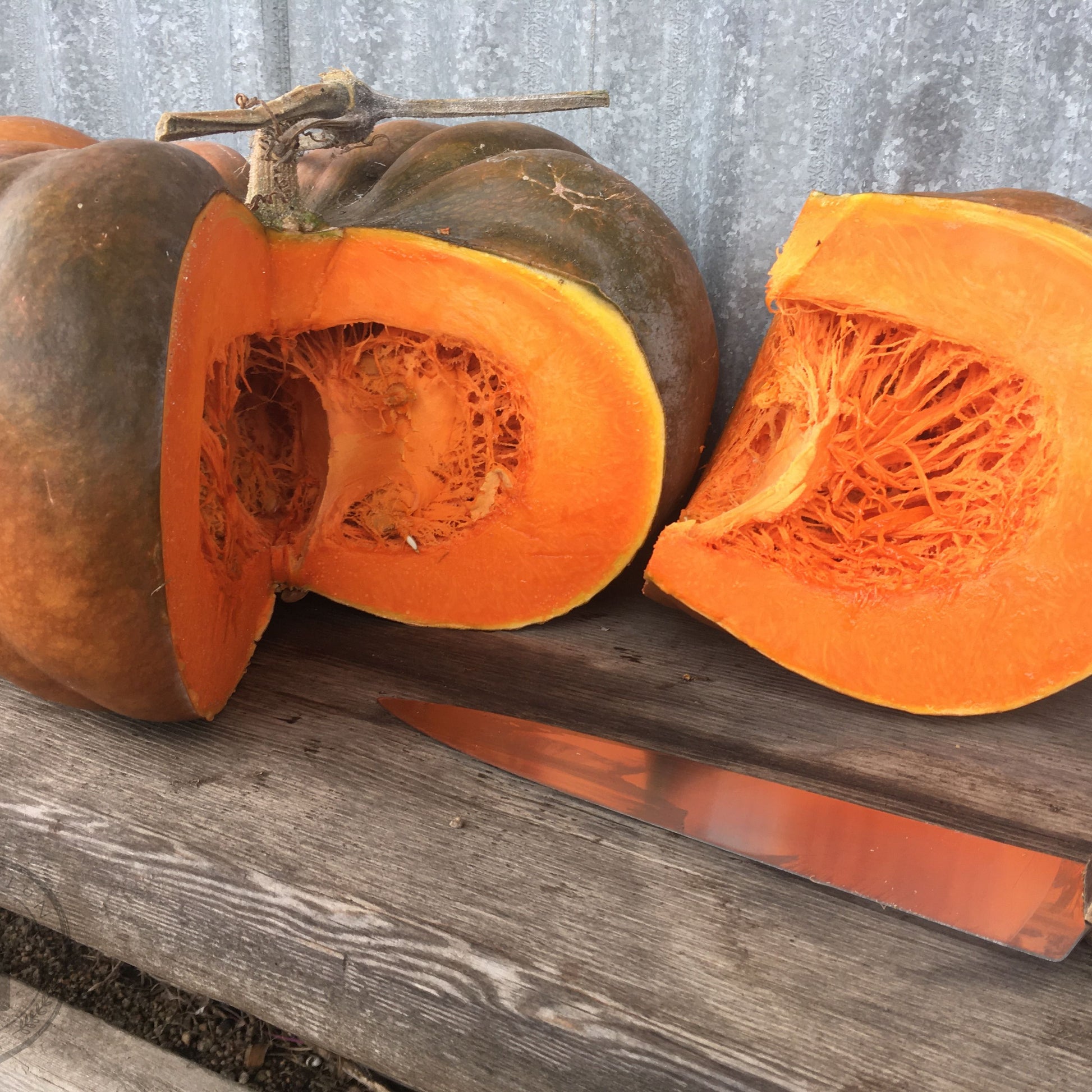 Sliced pumpkin on a wooden surface with a gray background