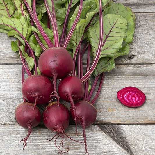 Bunch of fresh beets with green leaves on a wooden surface