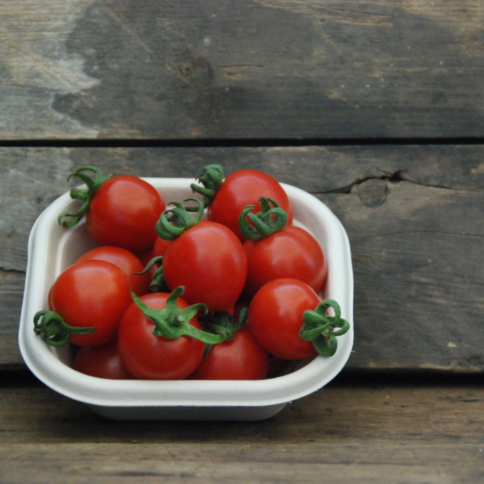 red cherry tomatoes in a small crate