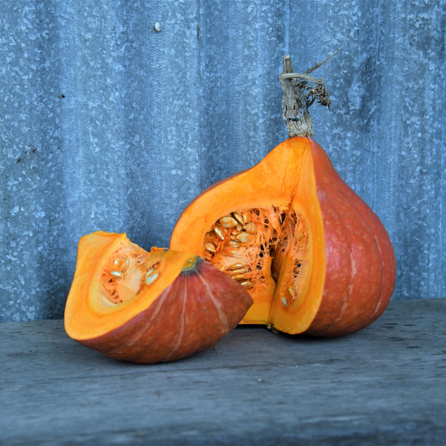 Sliced pumpkin on a blue surface with a textured blue background