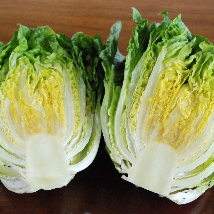 Halved green lettuce on a wooden surface