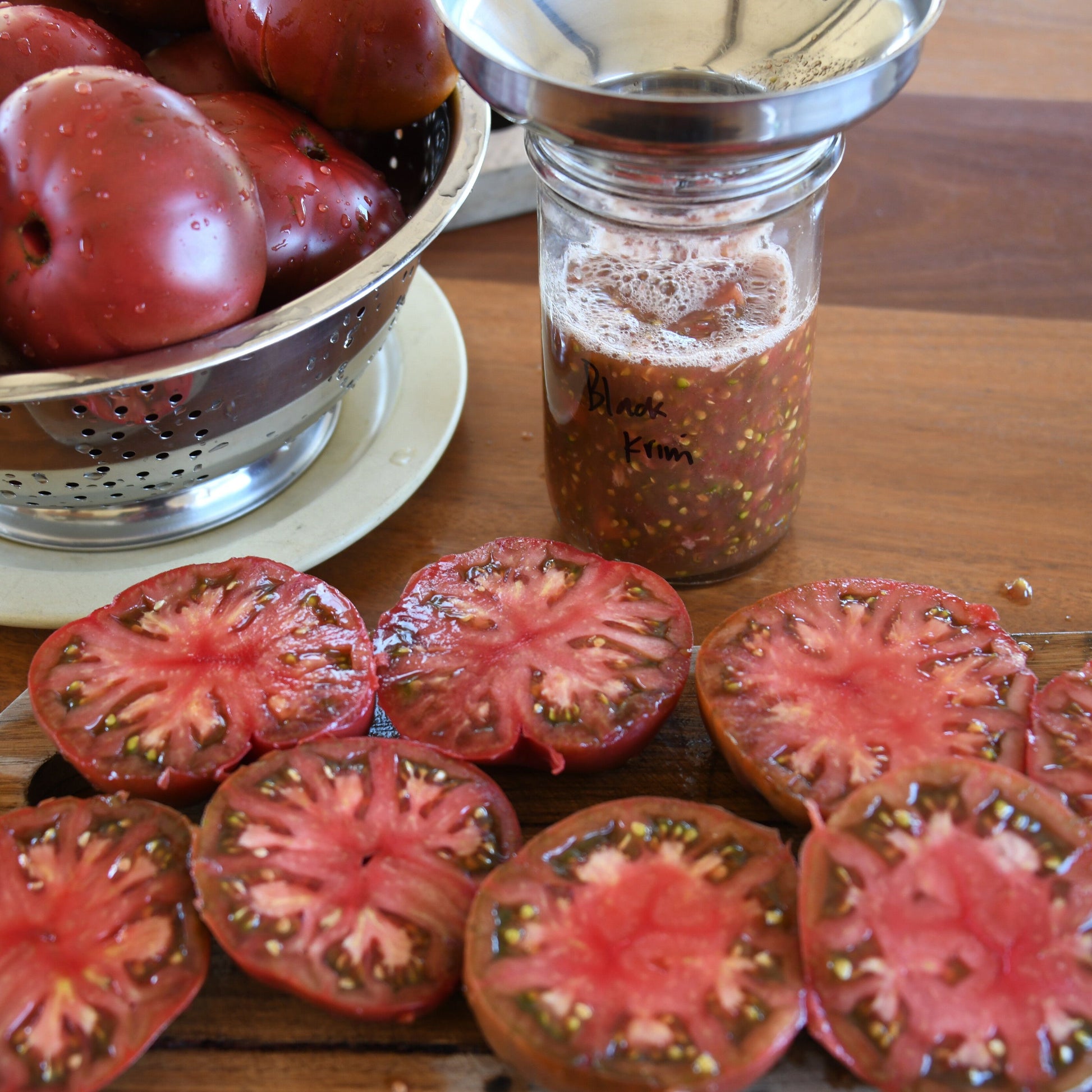 Tomatoe seed being processed on a wooden table.