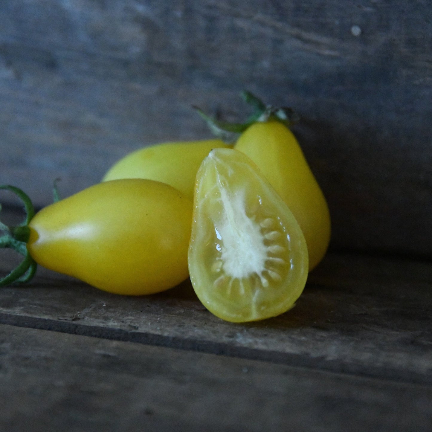 Yellow tomatoes on a wooden surface