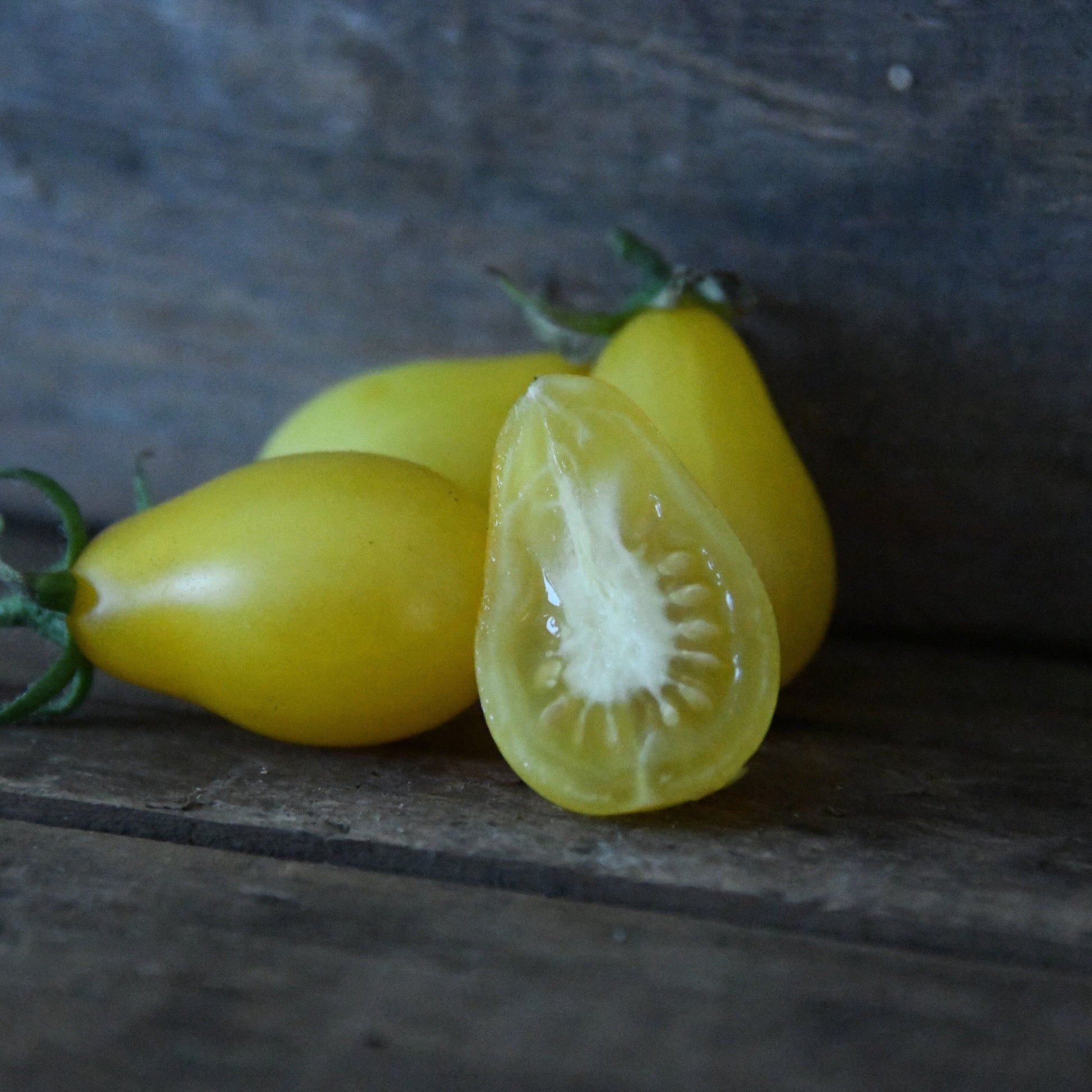 Yellow tomatoes on a wooden surface